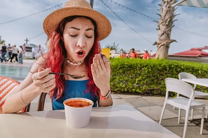 Image woman on beach reacting to hot spicy soup