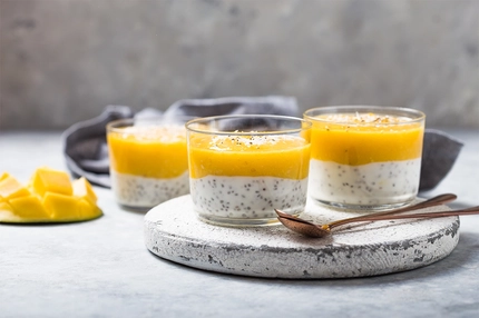 Chia seed pudding with mango in glass jars.