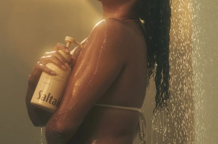 Image Woman in the shower holding a bottle of body wash