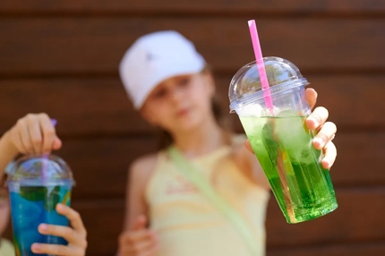 Image Child holding a drink in a plastic cup