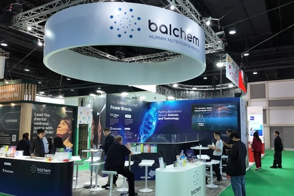 Image Balchem booth at tradeshow with people talking