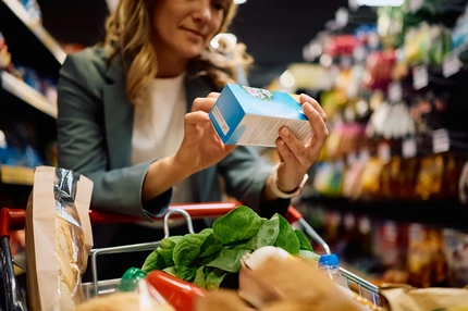 Close up of woman reading package label over grocery cart