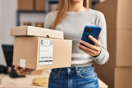 Image A person carrying packages while using a phone