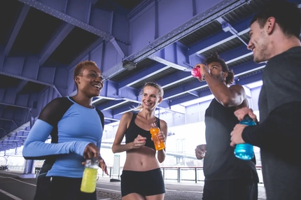 People drinking functional beverages under a bridge.