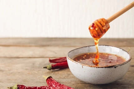 pouring hot honey in a soup bowl