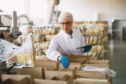 Image woman in white sterile uniform checking packaged food boxes