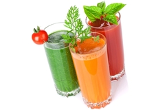 Image Three glasses of green, orange, and red vegetable juices