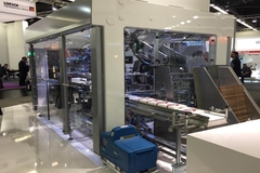 Schubert Lightline automated packaging machine at trade show with compact modular design and carton loading system