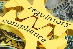 Image Golden gears labeled regulatory and compliance interlocking together