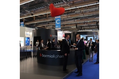 Trade show booth with Bormioli Pharma signage and attendees