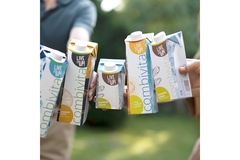 Image Hands holding colorful SIG combivita beverage cartons labeled “Live it up!”