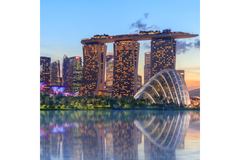 Singapore Marina Bay Sands hotel and skyline at dusk with Gardens by the Bay reflected in water