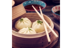 Image Steamed Chinese buns served in bamboo basket with chopsticks and dipping sauces