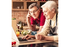 An old couple looking at a laptop