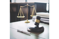 Image A gavel and scales of justice on a desk, symbolizing law and justice.