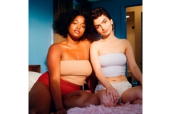 Two ladies sitting on bed