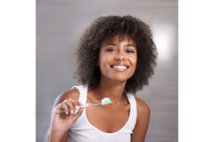 Image A lady with a nice smile holding a toothbrush in her hands