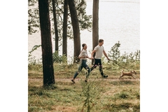Couple walking dog in forest