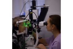 Image Female patient receiving eye test under green light.