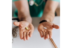 Person holding out two supplements in hands.