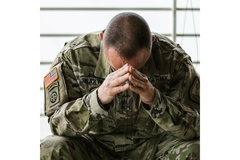 Image Solder holding his hands to his head.