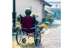 Image Elderly woman in a weelchair in the street.