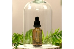 Image a glass jar over a brown glass bottle of essential oil showcasing sustainable formulation