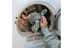 Image woman putting her laundry in the washing machine