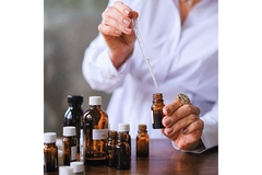 Image woman dipping a pipette in essential oil