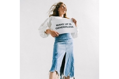 Image person holding poster saying that makeup is genderless