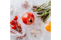 Image Fruits and vegetables wrapped in plastic bags.