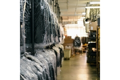Image coats hanging at a dry cleaning shop