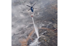 Image Naval helicopter drops water on Brahmapuram waste dump fire