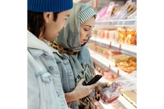 Image Man and woman in supermarket looking at a product label.