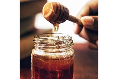 Image Wooden honey comb lifting honey out of jar