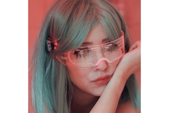 A futuristic-looking woman with colored hair wears sleek glasses that function as a digitized screen.