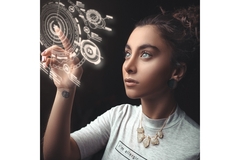 A woman interacts with a floating hologram.