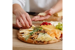 Woman selecting cheese to eat.
