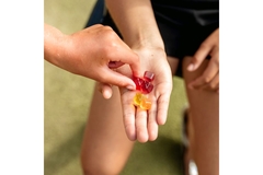 Person in workout clothes taking gummies