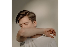 Image Person coughing in his elbow.