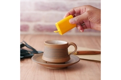 Image Person putting sweetener in coffee.