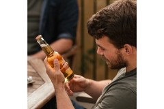 man looks at the label on a beer bottle
