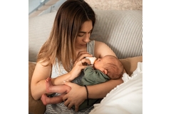 Image Woman feeding newborn baby.