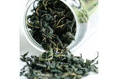 Image Green tea leaves spilling out of a jar.