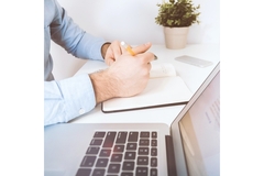 Image Man writing business strategy on paper and computer