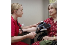 Image Doctor measuring a woman's blood pressure.