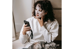 Image Girl wearing a face mask looking at her phone
