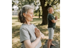 Woman doing yoga outside and breathing out.