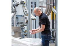 Image Sidel employee sifts through PET flakes