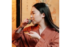 Image side profile of Asian lady drinking tea